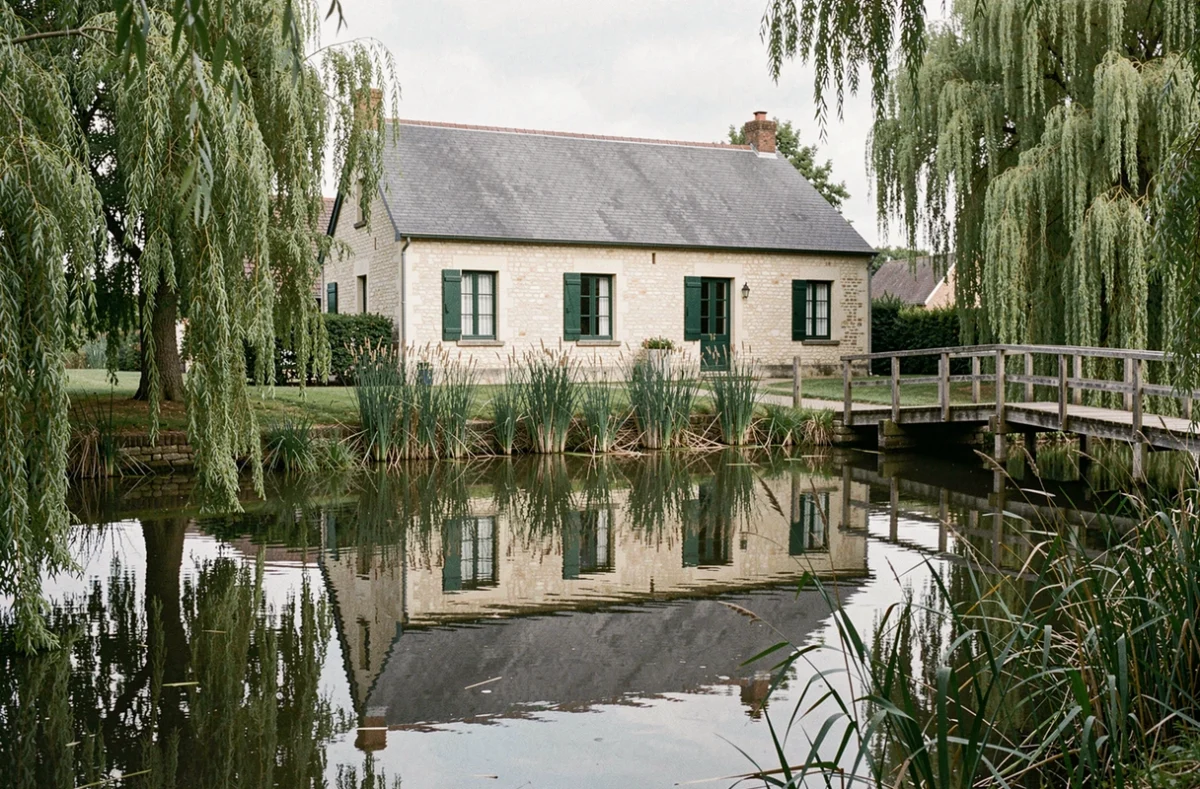 Maison individuelle de style Marais Poitevin construite par Maisons du Marais, avec murs en pierre et reflet dans le canal